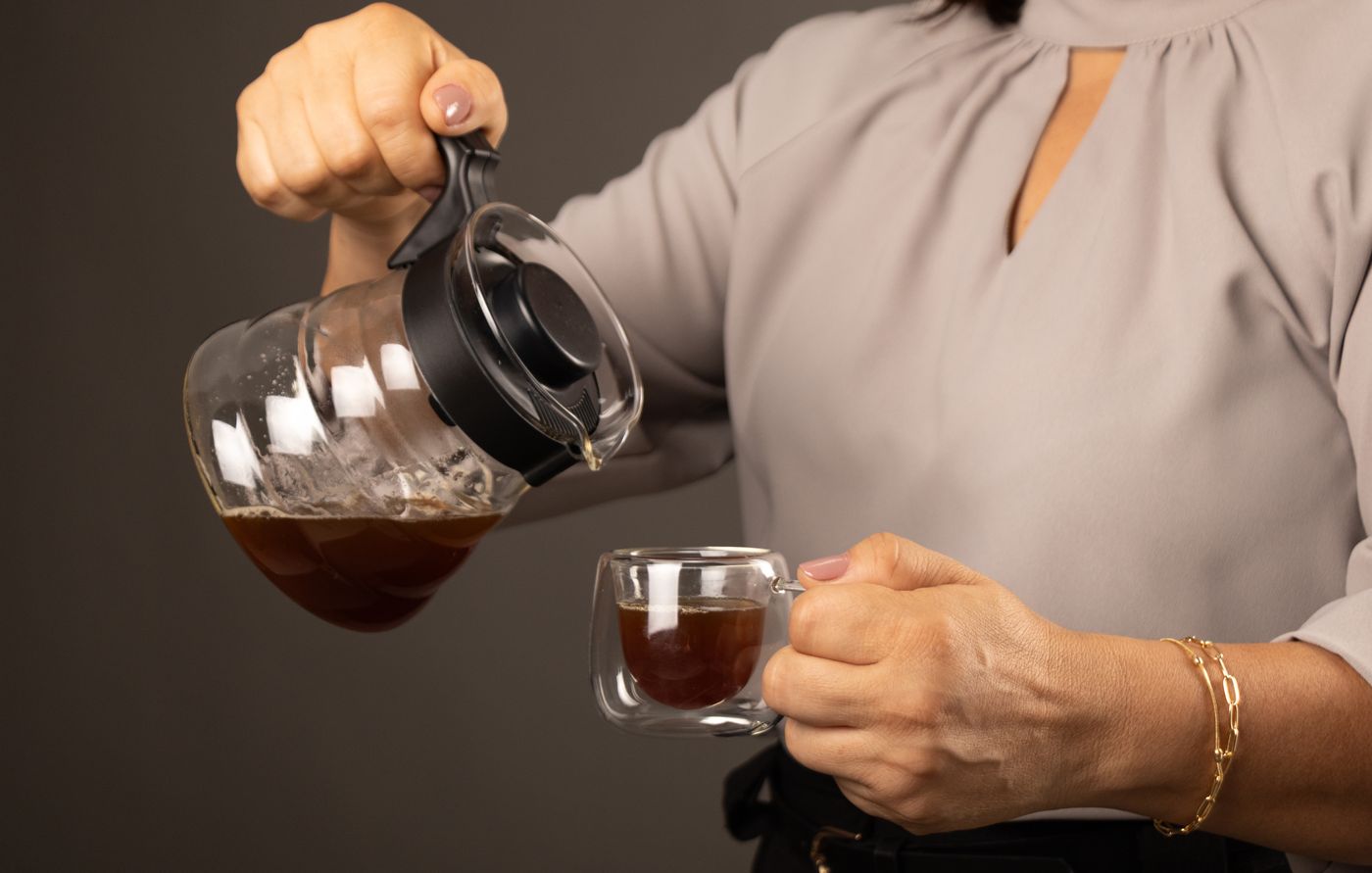 Café sendo servido em xícara de vidro